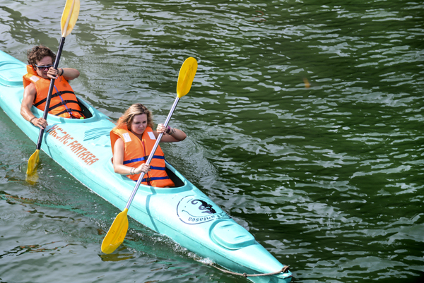 Du khách chèo thuyền kayak khám phá hang động trên vịnh